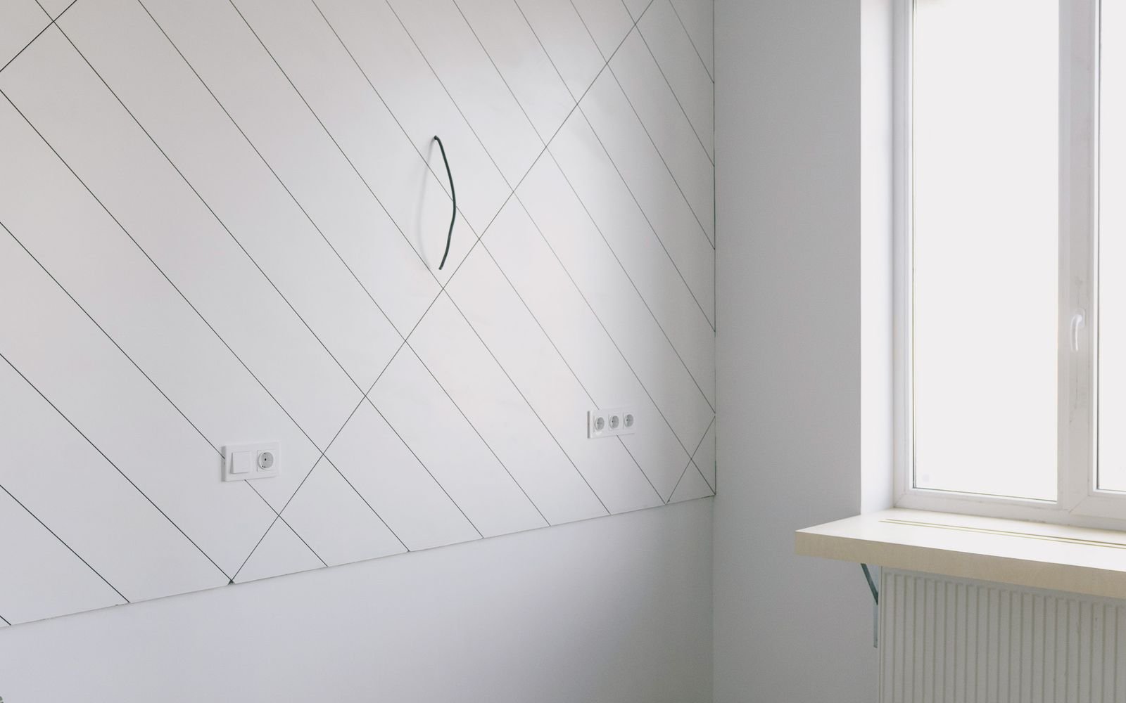 Pièce vide et propre aux murs blancs, parquet clair éclairé par la lumière du jour